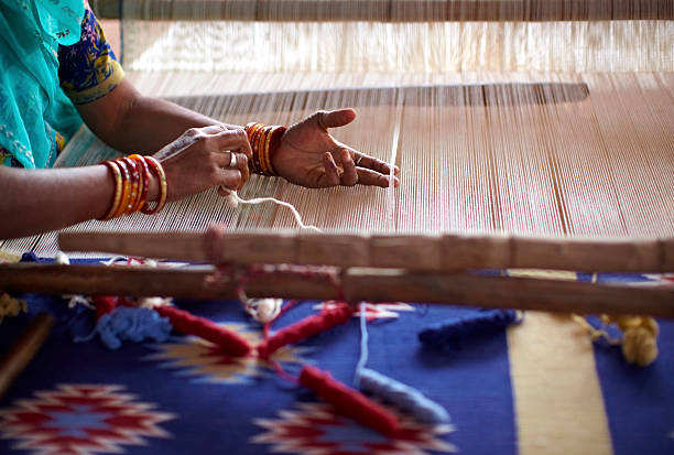 istock Indian woman weaving by hand on a loom 147631166