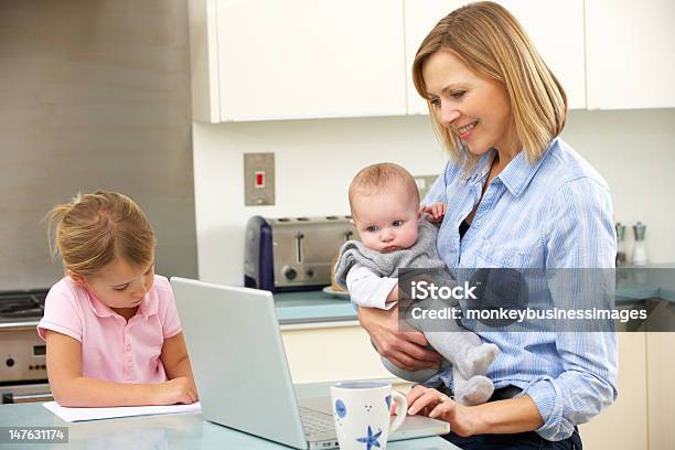 Mother With Children Using Laptop In Kitchen Stock Photo - Download Image Now - Baby - Human Age, Busy, Child