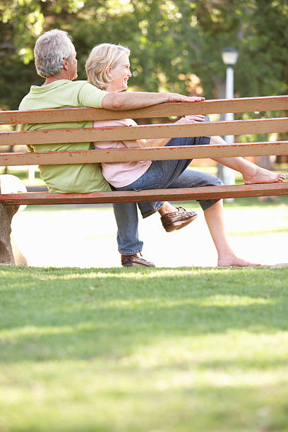 istock Senior Couple Sitting Together On Park Bench 147631356