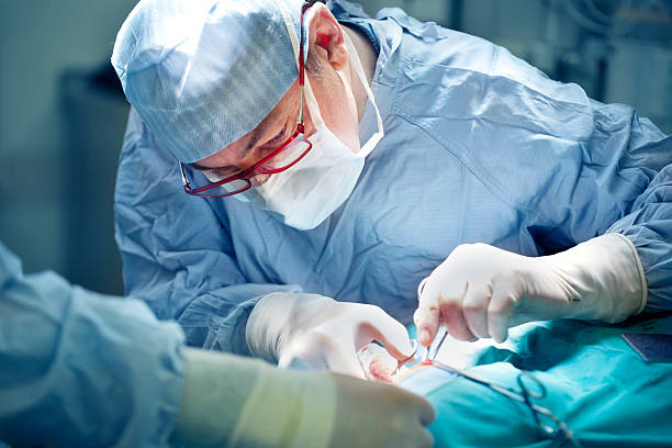 chirurgie chirurg performing - surgeon stock-fotos und bilder