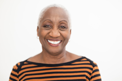 Happy senior black woman portrait against white background