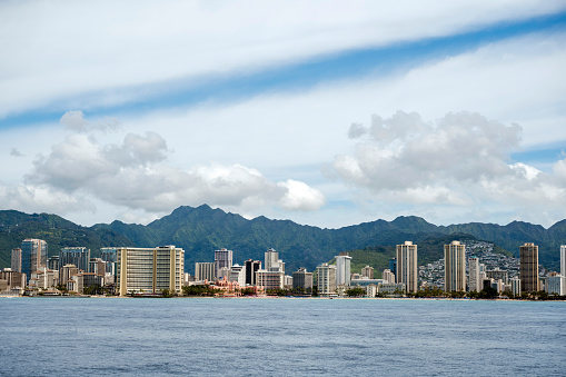 Waikiki cityscape seen from the water. Waikiki high rises and mountains in the background.