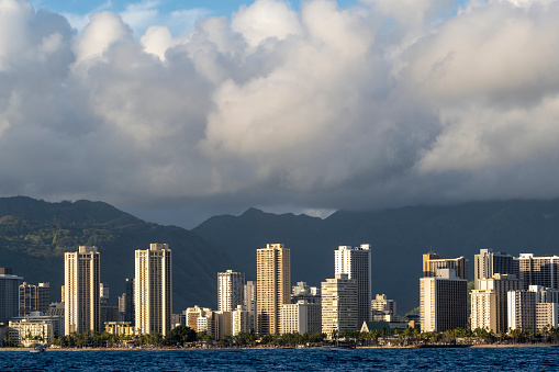 Waikiki cityscape seen from the water. Waikiki high rises and mountains in the background.
