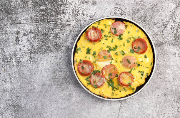 istock Omelet with herbs and sausage on a round plate on a dark grey background. Top view, flat lay 1476377884