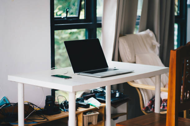 istock Laptop on white table black sceen in cozy house 1476418588
