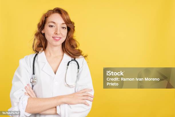 Redheaded Female Doctor Smiling At The Camera With Arms Crossed Stock Photo - Download Image Now