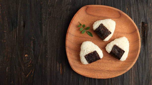 istock Japanese Triangle Onigiri on Wooden Plate 1476426942
