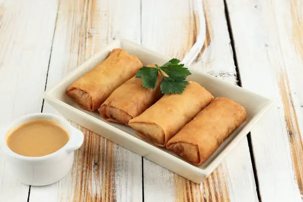 Lumpia or Loenpia Goreng, Deep Fried Spring Roll Served with Peanut Sauce, Usually Filled with Chicken, Shrimp, or vegetable. Typical Indonesian Fritter with Chinese Influence