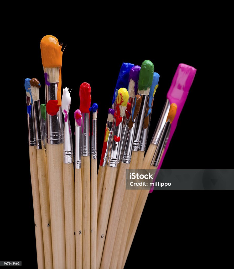 Paint Brushes on Black A variety of colorful wet paint brushes in front of a black background Art Stock Photo