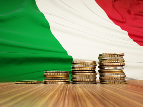 Rising stack of coins with Italian flag in the background. Economy, finance, interest rates concept.