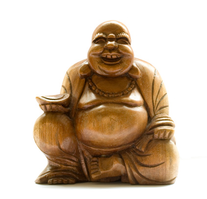 Isolated carved wooden statue of a laughing buddha on a white background.