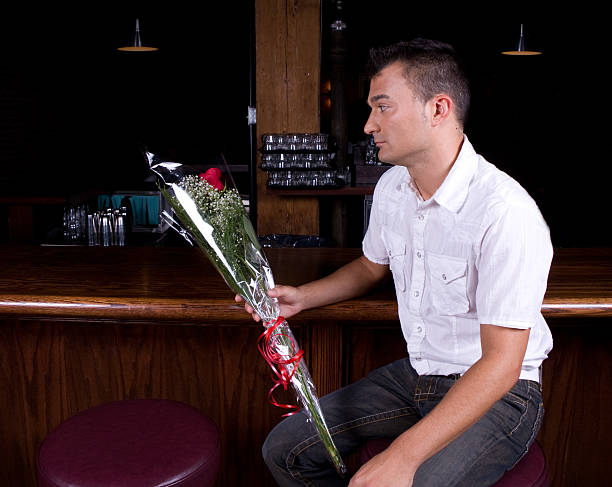 Blind Date Young man waiting with flowers for a blind date. blind date stock pictures, royalty-free photos & images