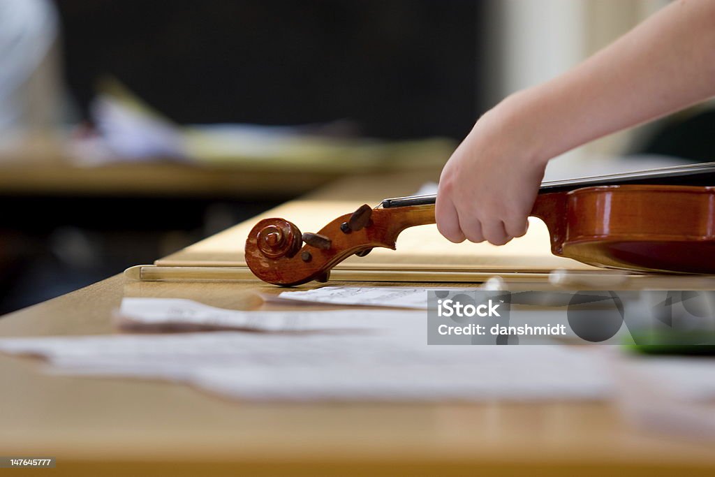 music calss Hand reaching for violin in a youth music class in London Childhood Stock Photo