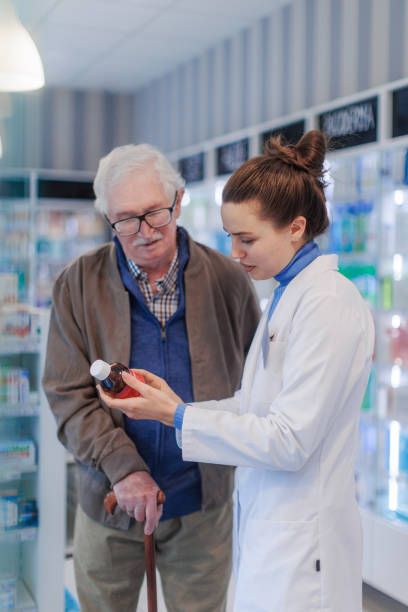 istock Young pharmacist helping senior man to choos medication. 1476462334
