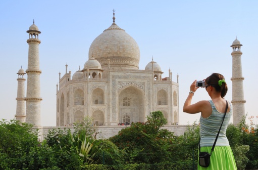 Young woman taking picture of Taj Mahal in Agra, India