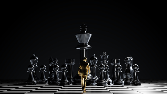 A single golden figure of a businessman walking at chessboard board to the group of black chess pieces with a giant king piece in the middle. Leadership, business strategy, career, the way forward concepts