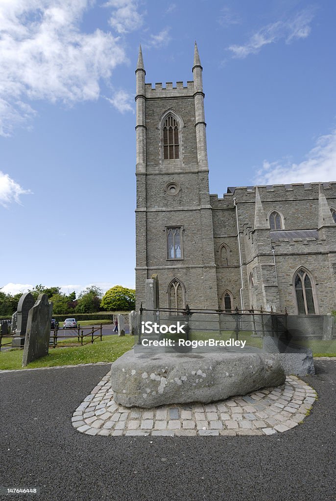 St Patrick's Traditional Grave, with Cathedral Tower behind Large rock marks the traditional site of St Patrick's grave in the grounds of St Patrick's Cathedral Church, Downpatrick, Co Down, Northern Ireland. Downpatrick Stock Photo