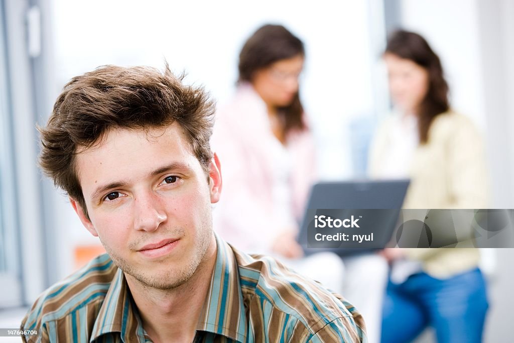 Businessman and business team Young happy businessman looking at camera, smiling while business team working in background. Click here for other business images: Business Stock Photo