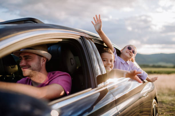 Happy family enjoying drive in their new electric car. stock photo