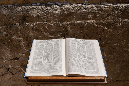 A Talmud open to the text from the tractate Ketubot rests on a prayer stand in front of the Western Wall in Jerusalem.