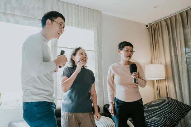 istock Two generation family enjoy singing and dancing karaoke at home 1476476808