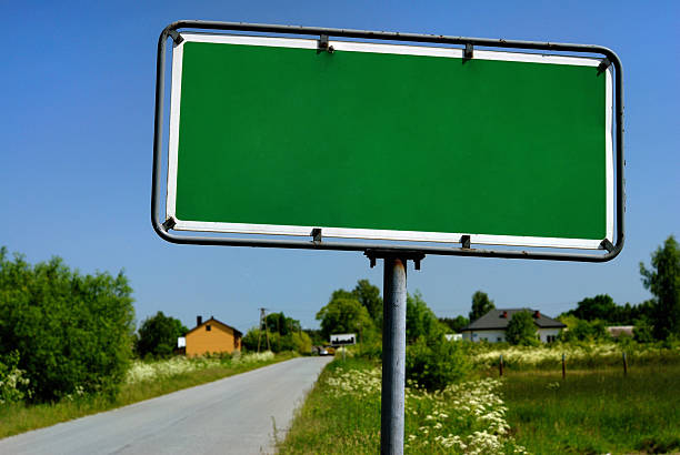 istock Road sign with village in background 147648235