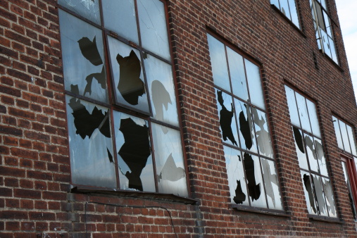 Boarded old window with broken glass panels