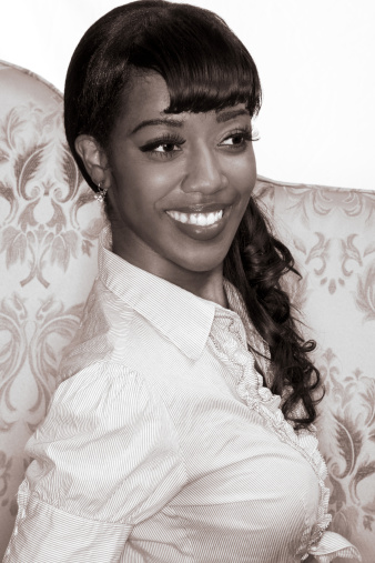 Portrait of happy Afro-American young woman in 50s-60s retro style - monochrome image is sepia toned