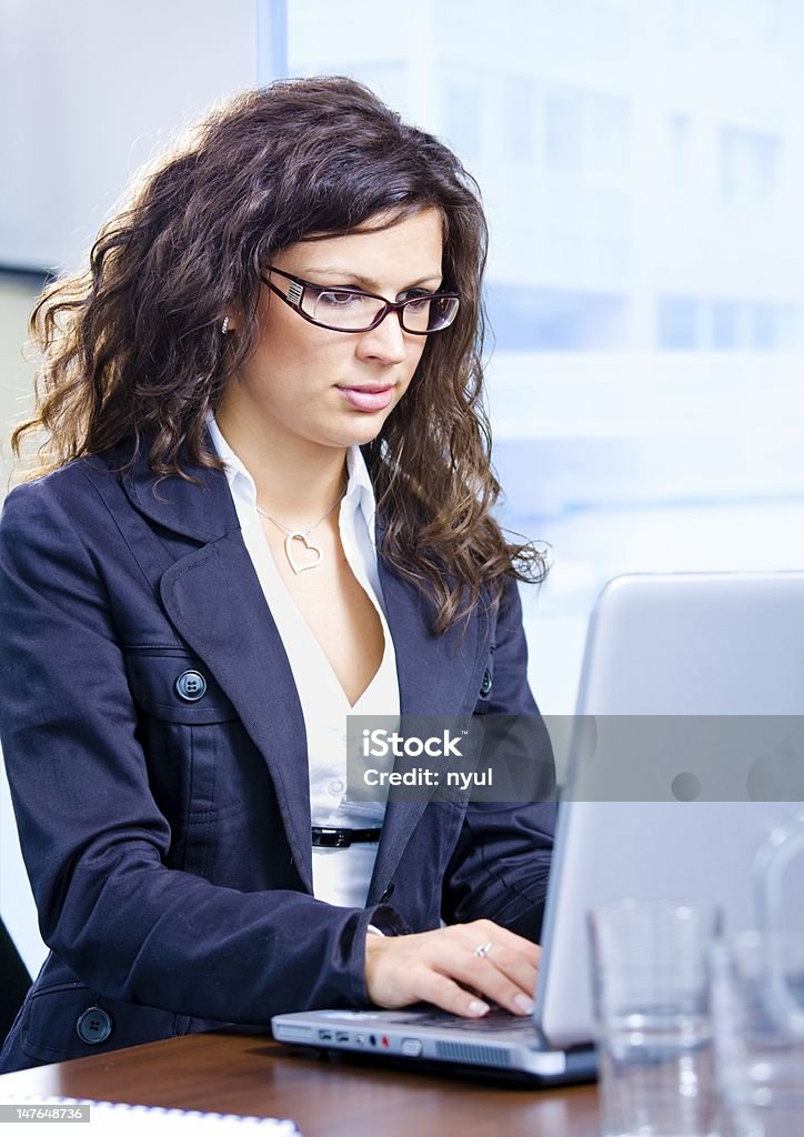 Businesswoman using laptop Businesswoman using laptop computer at office.  Click here for other business images:  20-24 Years Stock Photo