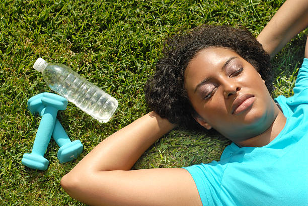 Woman resting in the grass after working out stock photo