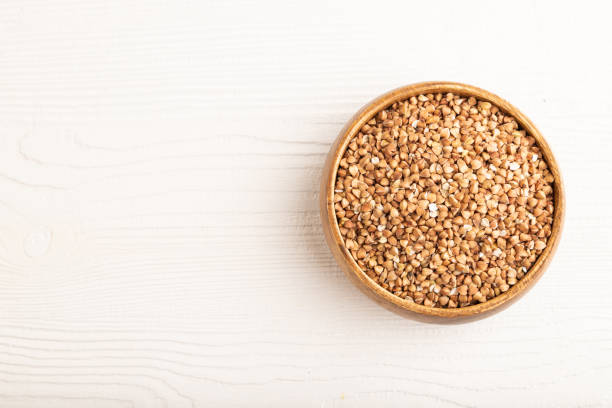 istock Raw buckwheat on white wooden, top view, copy space 1476495848