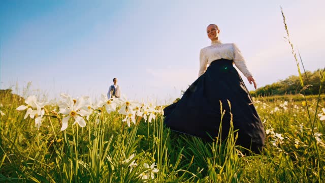 SLO MO WS Woman in traditional clothes twirls in the meadow