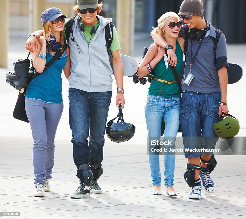 Felice giovane coppia camminare insieme sulla strada - Foto stock royalty-free di Abbigliamento casual