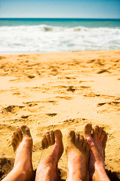 istock Two pairs of Feet Relaxing on Beach 147650254