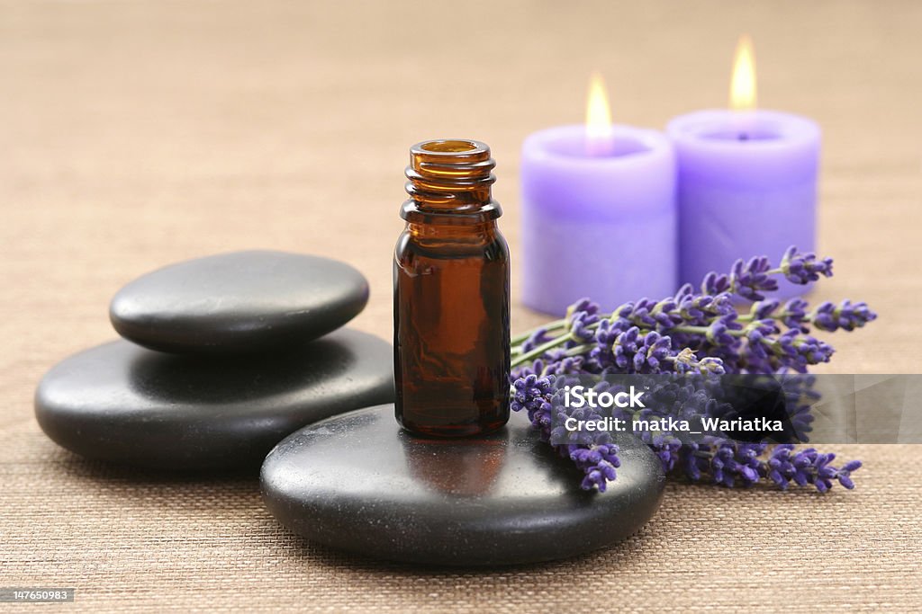 Pebbles, lavender, candles and an aromatherapy pot lavender flower black pebbles and lavender oil - spa treatment Lavender - Plant Stock Photo