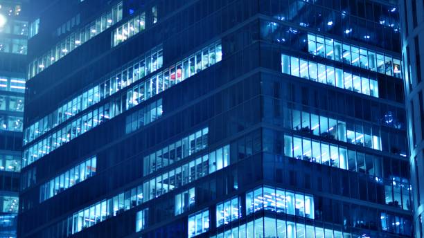 istock Pattern of office buildings windows illuminated at night. 1476509923