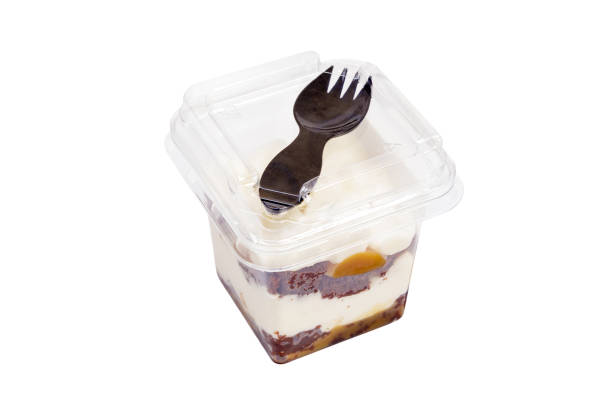 istock Portion of chocolate caramel mousse in a plastic cup with a fork on the lid on a white background. 1476513602
