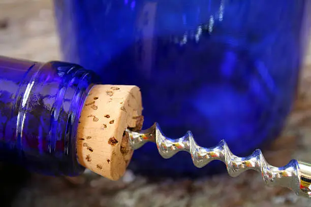 Close up of a wine cork and corkscrew.