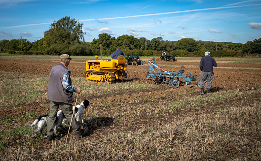 People watch as a  competitor in a traditional farming ploughing match sits on his vintage tracked Caterpillar tracked tractor ploughing his area at Oakhurst Farm, near Billingshurst, West Sussex, UK, 24 Sep, 2022.\nPloughing matches are popular within British rural and farming communities and are found taking place each autumn after harvest is completed.