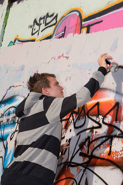 istock Teenage spray painter painting colorful graffiti 147652285