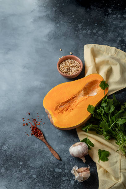 istock Ingredients for pumpkin soup with spices and herbs on a dark background 1476525440