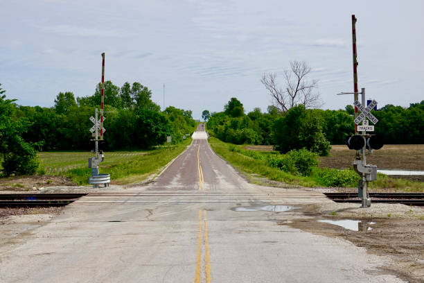 istock Railroad crossing intersects small town two lane road 1476530772
