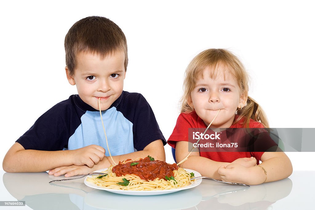Kids eating pasta Happy kids eating pasta - isolated Beautiful People Stock Photo