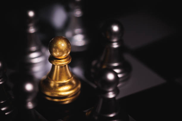 istock Gold color pawn chess piece surround by silver chess piece. 1476551449