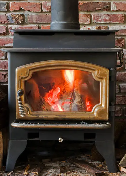 Cozy fire in wood burning stove glows brightly.