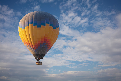 Colorful hot air balloon flying above the clouds