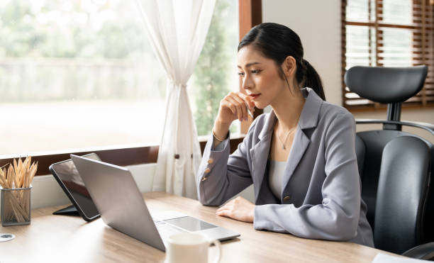 istock Serious female freelancer working online with accounting documents on modern laptop. Business woman busy working on laptop computer at office. 1476567131