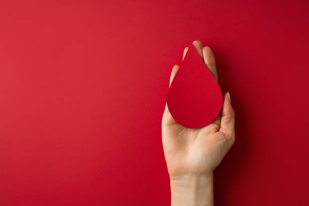 World donor day concept with hand holding paper red drop on white background World donor day concept with hand holding paper red drop on red background, top view. copy space blood test stock pictures, royalty-free photos & images