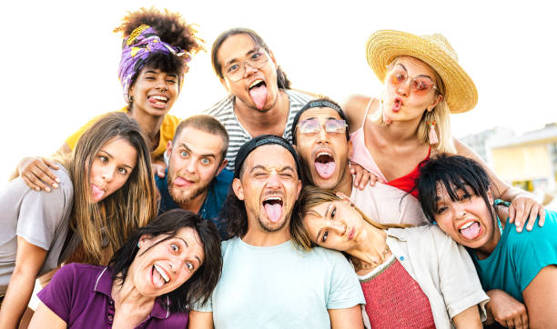 istock Multicultural mixed age people taking selfie sticking out tongue making funny faces - Crazy life style and integration concept with interracial young friends having fun together - Bright vivid filter 1476569061