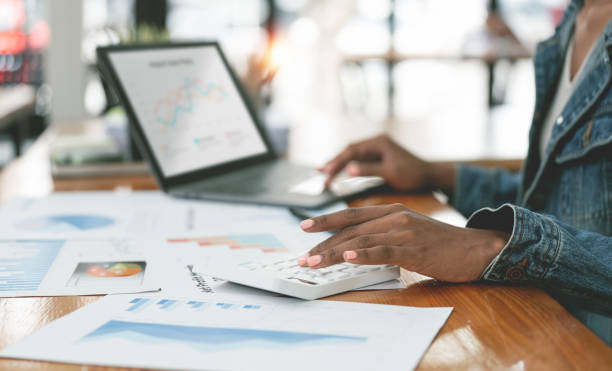 istock Cropped shot of ethnic businesswoman working document, analyzing business graph chart, planning finance and marketing investment on her desk office. 1476571524